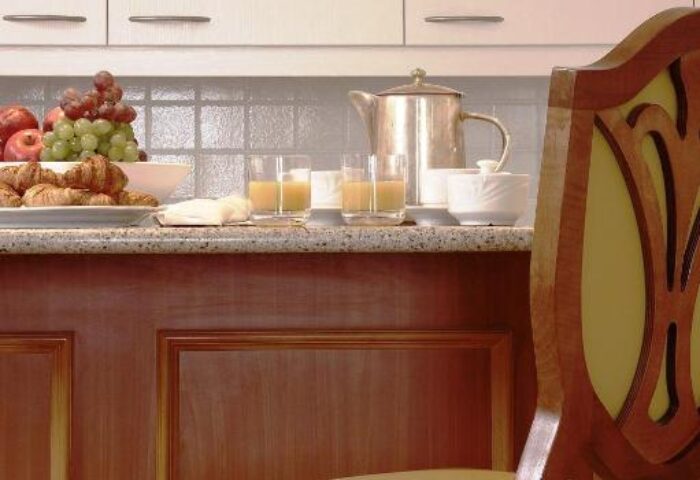 Millennium Court Budapest Marriott Executive Apartments breakfast bar. Gay-friendly hotel with kitchen, juice, fruit, pastries, and chair.