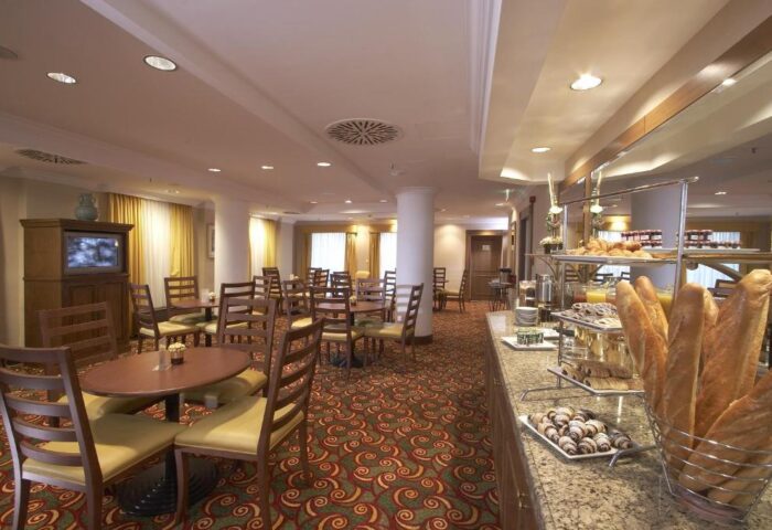 Millennium Court Budapest Marriott Executive Apartments' breakfast area. Gay-friendly hotel with buffet, tables, and chairs.