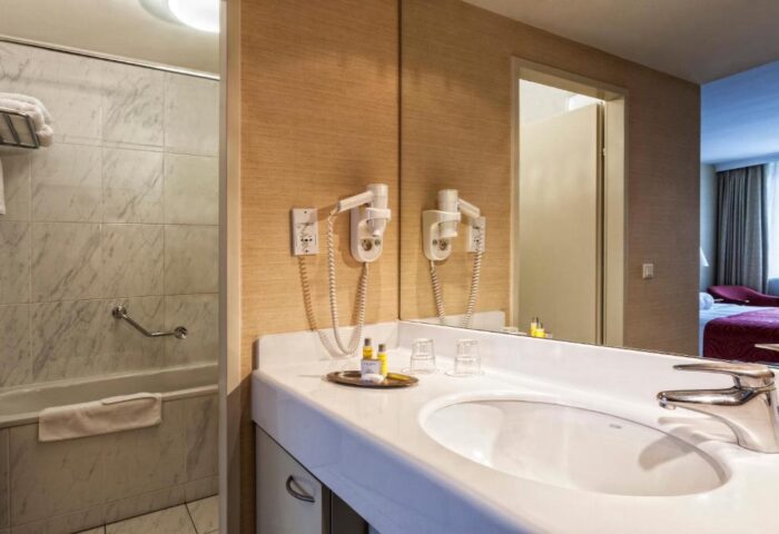 Bathroom at Gay-Friendly Millennium Court Budapest Marriott Executive Apartments. Sink, mirror, and bathtub. Hotel for gay men in Budapest.
