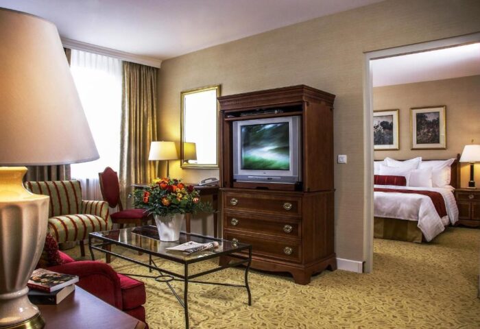 Millennium Court Budapest Marriott Executive Apartments suite. Living room, TV, bedroom view. Gay-friendly hotel for gay men travelers.