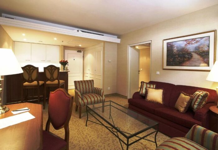 Millennium Court Budapest Marriott Executive Apartments suite. Gay-friendly hotel living room with sofa, chairs, desk, and bar. Budapest apartment.