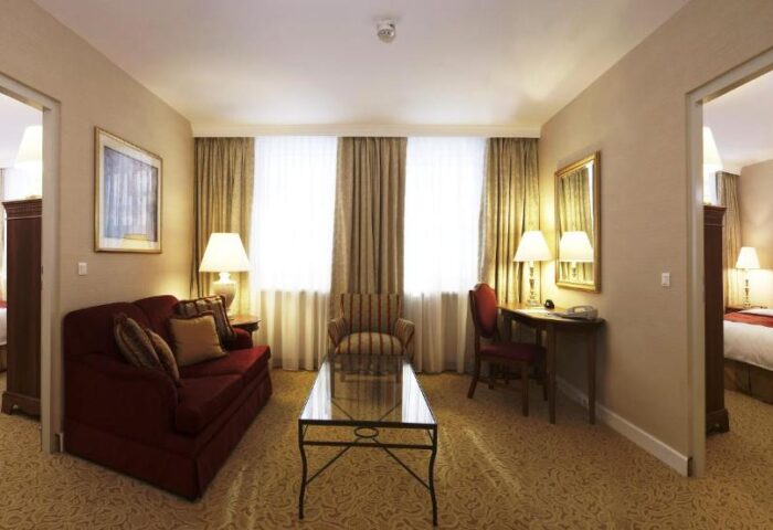 Millennium Court Budapest Marriott Executive Apartments suite. Gay-friendly hotel with living room, desk, and bedroom views. Comfy, stylish stay.
