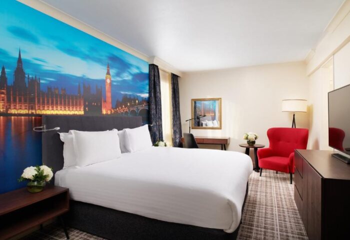 Millennium Gloucester Hotel London bedroom. Gay-friendly hotel with a double bed and a mural of the Houses of Parliament and Big Ben.