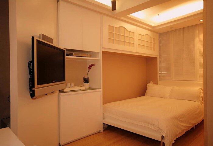 Mingle At The Eden gay-friendly hotel room. Compact design with a bed, TV, storage, and window. Ideal for gay men travel.