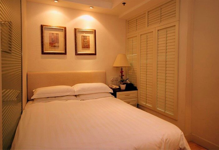 Mingle At The Eden gay-friendly hotel room. Bedroom with double bed, bedside table, lamp, and shuttered windows. Ideal for gay travel.