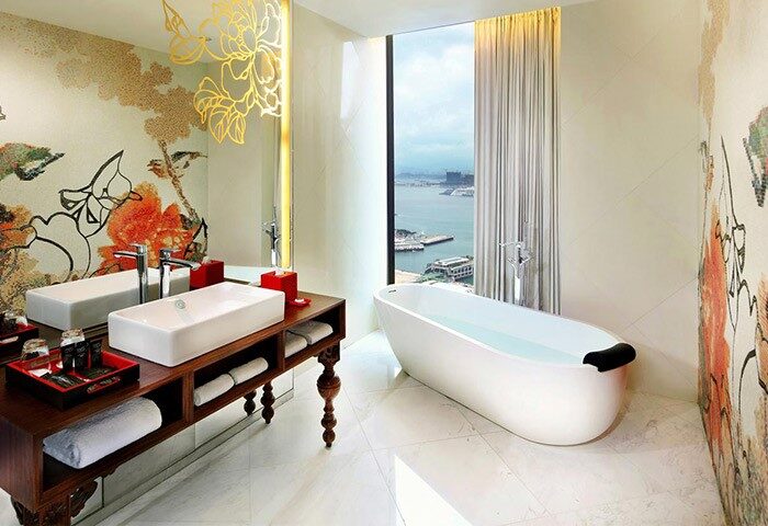 Mira Moon Hotel bathroom. Gay-friendly hotel with bathtub overlooking Hong Kong. Luxury travel for gay men. Modern design with Asian-inspired art.