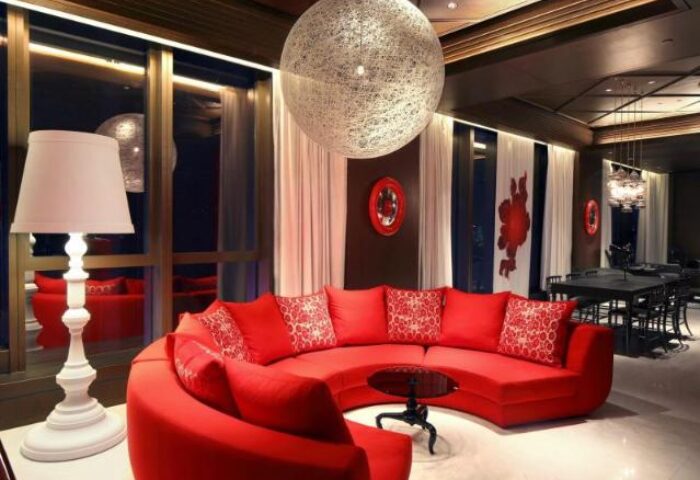 Mira Moon, gay-friendly hotel: Red circular sofa, white lamp, and modern decor create a stylish, inviting space. Perfect for LGBT travelers.