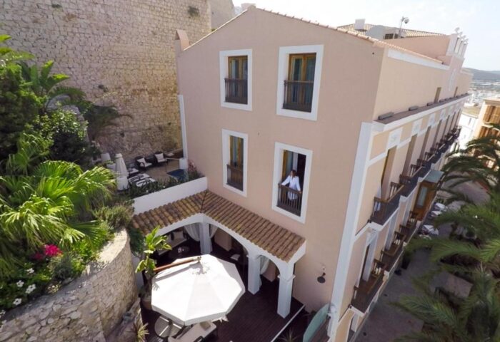 Mirador de Dalt Vila-Relais & Chateaux: Gay-friendly hotel exterior. Balconies, palm trees, and a view of Ibiza. A luxurious travel destination.