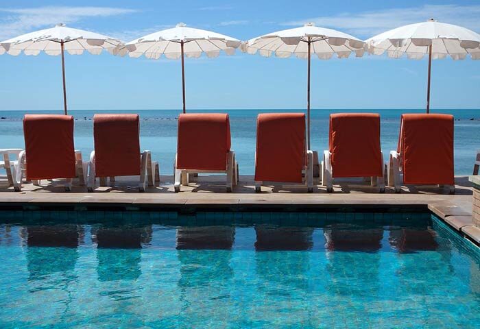Montien House Hotel gay-friendly resort: Poolside loungers and umbrellas offer relaxation by the sea. Ideal for gay travel.