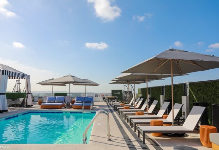 Rooftop pool at Montrose at Beverly Hills, a gay-friendly hotel. Lounge chairs, umbrellas, and cabanas offer relaxation in the sun.