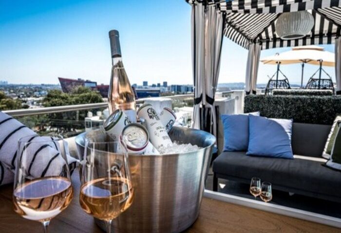 Montrose at Beverly Hills gay-friendly hotel rooftop. Wine glasses, ice bucket with drinks, and city views. Luxury travel for gay men.