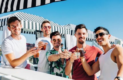 Montrose at Beverly Hills gay-friendly hotel: Group of gay men toasting drinks at the bar. A luxury travel experience for gay travelers.