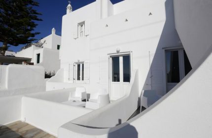 Morfoula's Studios: White exterior of a gay-friendly hotel. Balcony with chairs and table. Traditional Greek architecture. Ideal gay travel.