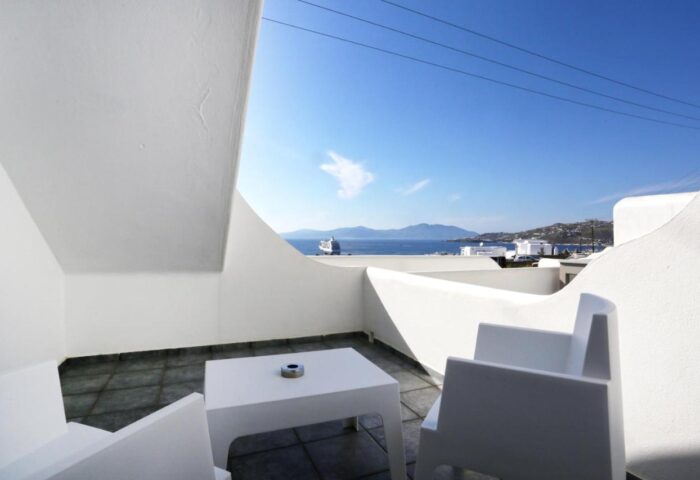Morfoula's Studios: Balcony view from this gay-friendly hotel. White chairs, table, sea and sky. Perfect for gay travel in Mykonos.