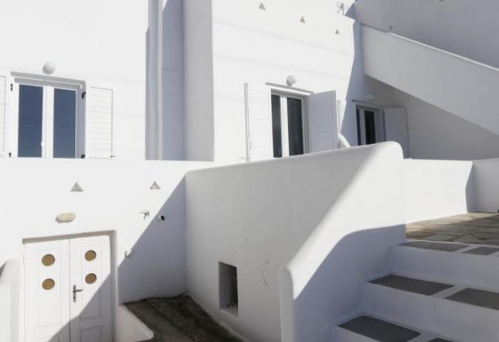 Morfoula's Studios, a gay-friendly hotel. Traditional Greek architecture with whitewashed walls, windows with shutters, and steps.