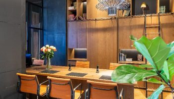 Mosaic House Design Hotel interior. Gay-friendly hotel with modern design, wooden furniture, library, and stylish chairs. Perfect for gay travelers.