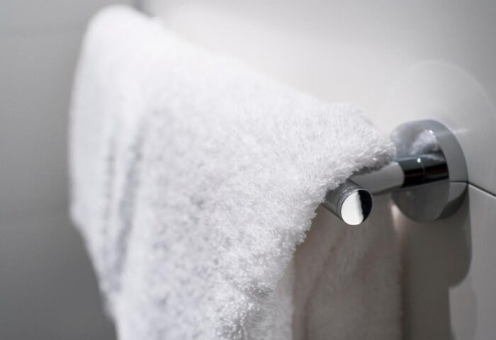 Towel rack at Motel One Koln-Neumarkt. Gay-friendly hotel detail: a fluffy white towel hangs on a modern, chrome towel bar. Cleanliness.