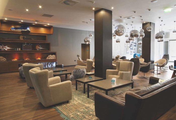 Motel One Manchester-Piccadilly's stylish lounge area. This gay-friendly hotel features modern decor, comfortable seating, & unique lighting.