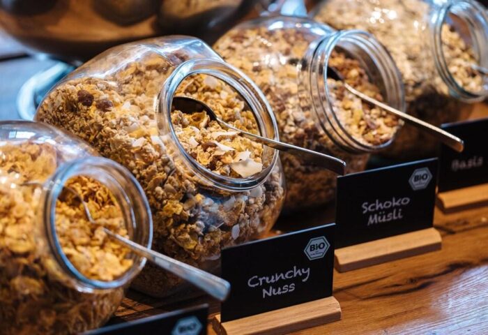 Breakfast bar at the gay-friendly Motel One Manchester-Piccadilly. Jars of muesli, including Crunchy Nuss and Schoko Müsli, with serving spoons.