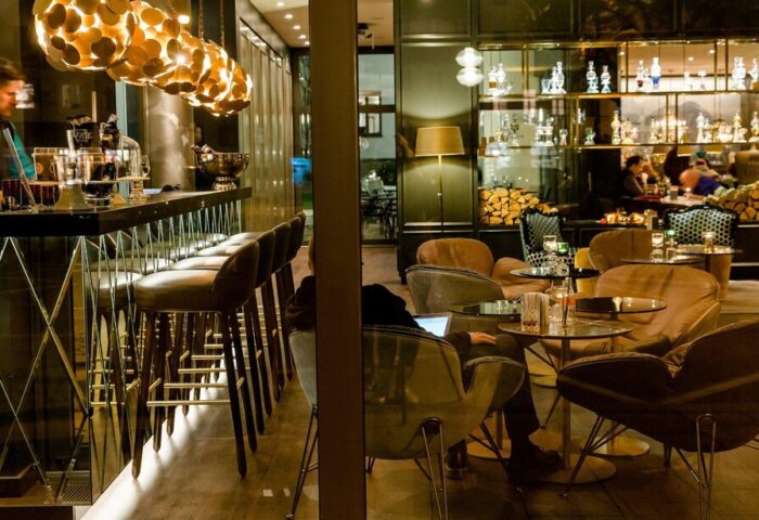 Motel One München Sendlinger Tor's bar area, a gay-friendly hotel. Stylish bar with seating, bartender, and lounge area for relaxing.