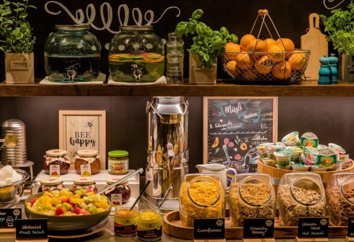 Breakfast buffet at Motel One München Sendlinger Tor, a gay-friendly hotel. Fruit salad, cereal, yogurt, juice, and other delicious options.