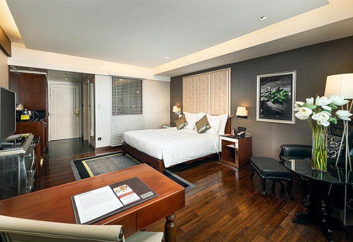 Movenpick Hotel Hanoi room. Gay-friendly hotel with a king bed, desk, and seating area. Upscale decor, wood floors. Hanoi travel advice.