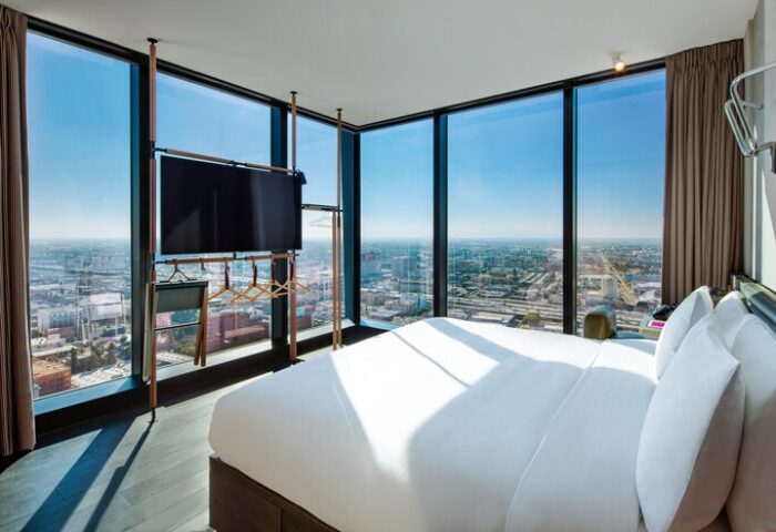 Moxy Downtown Los Angeles hotel room with city view. Gay-friendly hotel with modern design, large windows, and comfortable bed. Perfect for gay travel.