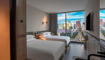 Moxy Downtown Los Angeles hotel room with two beds and city view. Gay-friendly hotel with modern design. Perfect for gay travel.