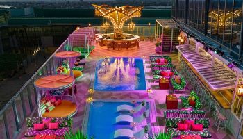 Rooftop pool and bar at the gay-friendly Moxy Downtown Los Angeles hotel. Stylish seating areas and city views. Vibrant, inclusive travel destination.