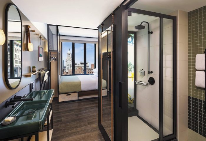 Moxy NYC East Village hotel room. Modern design with a view. Gay-friendly lodging in NYC. Stylish bathroom and bedroom. Urban hotel.