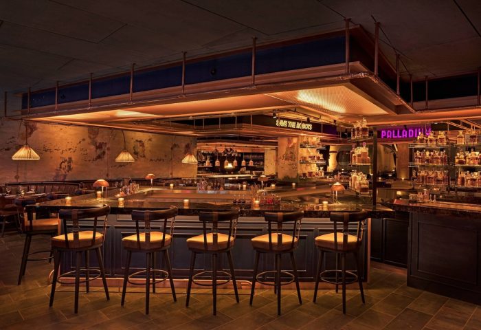 Moxy NYC East Village gay-friendly hotel bar. The bar has stools, dim lighting, and a sign that says Palladium.