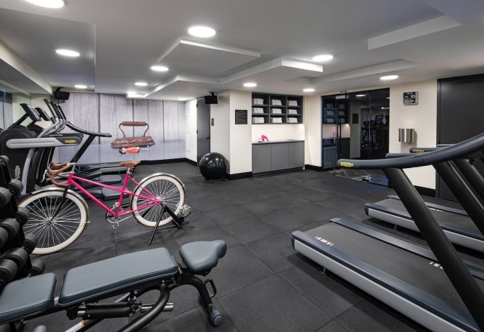 Moxy NYC East Village gay-friendly hotel gym. Treadmills, weights, and a pink bicycle for a unique workout experience. Fitness in NYC.