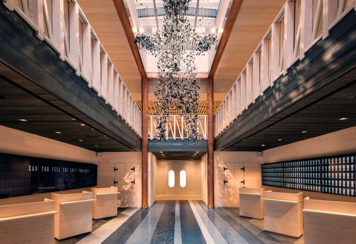 Moxy NYC Times Square hotel lobby. Interior of this gay-friendly hotel with light wood accents, and a sculpture hanging from the ceiling.