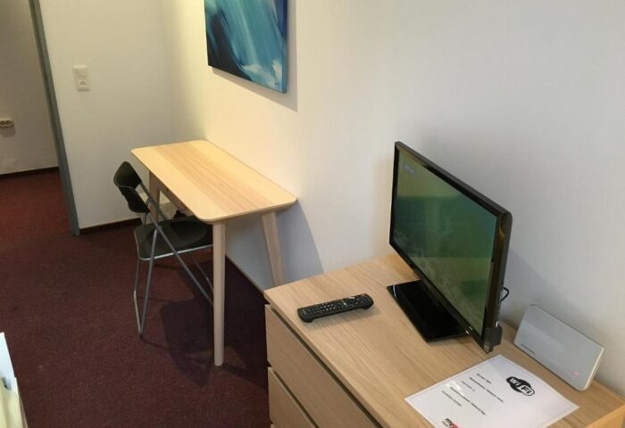 My Gayhostel room: Desk, chair, TV, and Wi-Fi info. Gay-friendly hotel for gay men's travel. Comfy stay at My Gayhostel.