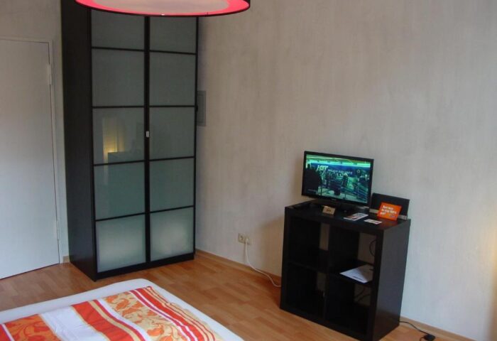 My Gayhostel room: Modern gay-friendly hotel room with TV, closet, bed. Ideal for gay men's travel. Stylish, comfortable, and welcoming.