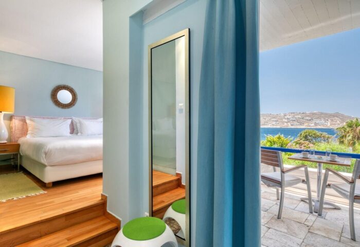 Mykonos Theoxenia gay-friendly hotel room with sea view. Balcony with chairs and table. Luxury gay travel in Mykonos, Greece.