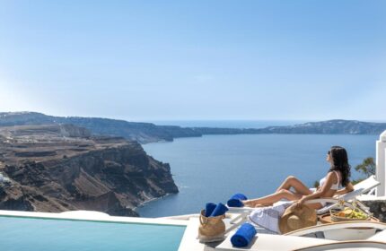 Woman relaxing at Mythical Blue Luxury Suites, a gay-friendly hotel. Ocean view from Santorini. Perfect for gay travel and vacations.