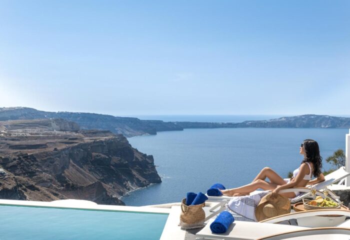 Woman relaxing at Mythical Blue Luxury Suites, a gay-friendly hotel. Ocean view from Santorini. Perfect for gay travel and vacations.