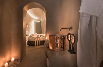 Mythical Blue Luxury Suites gay-friendly hotel room. Copper sink, arched doorway to bedroom, candles. Luxury gay travel.