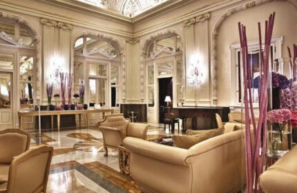 NH Collection Carlo IV's elegant lobby. This gay-friendly, pet-friendly hotel features stylish decor, ornate mirrors, and luxury seating.