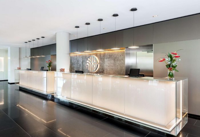 Reception area at the gay-friendly NH Collection Frankfurt City Hotel. Modern design, clean lines, and stylish lighting.