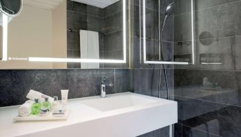Bathroom at NH Collection Frankfurt City, a gay-friendly hotel. Features modern design, sleek fixtures, and upscale amenities. Ideal for gay travelers.
