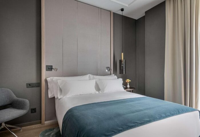 NH Collection Madrid Gran Via gay-friendly hotel room. Pet-friendly. Modern decor with a comfortable bed and stylish furnishings.