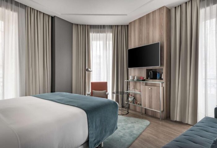 NH Collection Madrid Gran Via pet-friendly hotel room. Modern design, TV, minibar, and comfortable bed. Gay-friendly lodging in Madrid, Spain.