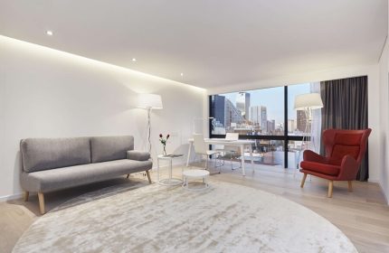 NH Collection Mexico City Reforma gay-friendly hotel room. Modern interior with sofa, desk, chair, and city view. Ideal for gay travel.
