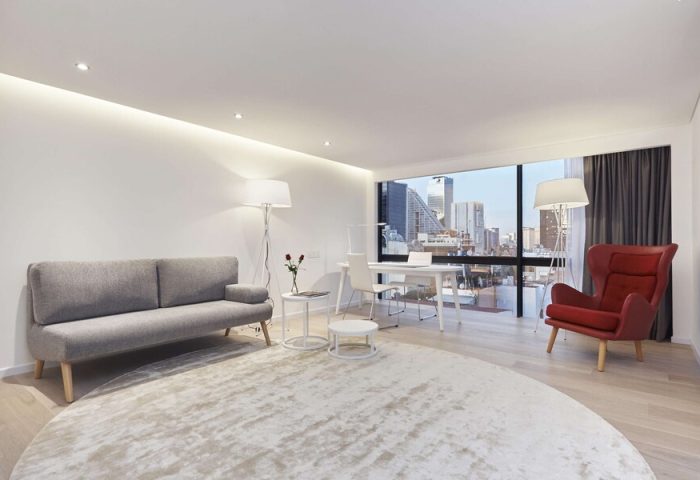 NH Collection Mexico City Reforma gay-friendly hotel room. Modern interior with sofa, desk, chair, and city view. Ideal for gay travel.