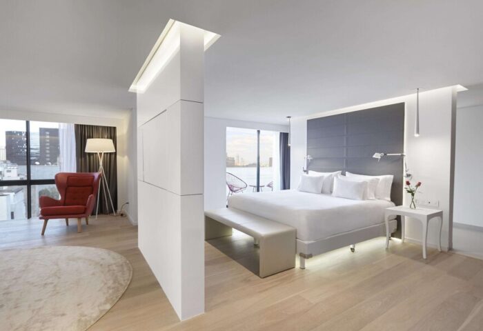 NH Collection Mexico City Reforma gay-friendly hotel room. Modern design with a king bed, red chair, and city view. Ideal for gay travelers.