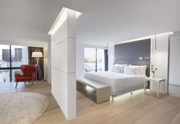 NH Collection Mexico City Reforma gay-friendly hotel room. Modern design with a king bed, red chair, and city view. Ideal for gay travelers.