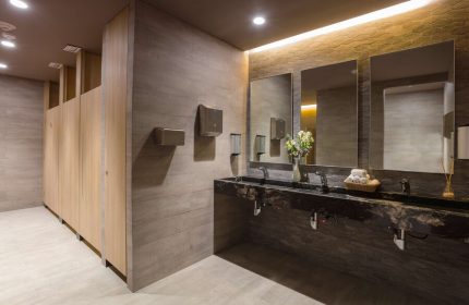 Bathroom at Gay-Friendly Hotel NH Collection Mexico City Reforma. Modern design with sinks, mirrors, and stalls. Stylish and clean restroom.