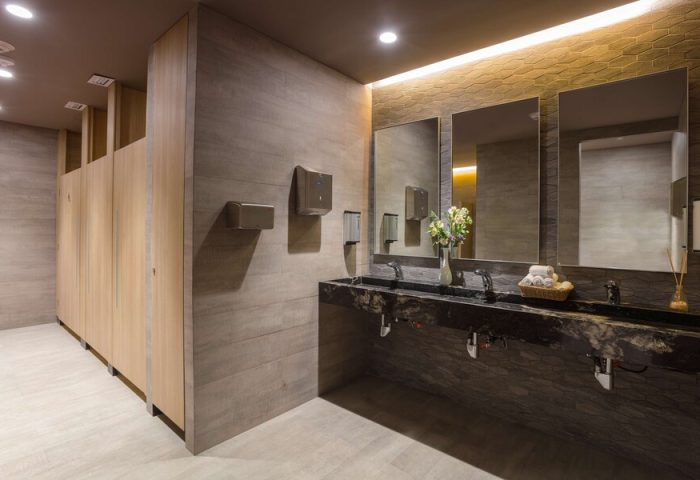 Bathroom at Gay-Friendly Hotel NH Collection Mexico City Reforma. Modern design with sinks, mirrors, and stalls. Stylish and clean restroom.